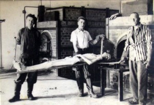 Dachau prisoners placing a corpse in a cremation over folloing the liberation of the camp.